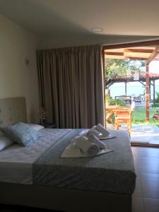 a hotel room with a bed with towels on it at Filippos Resort by the Sea in Vourvourou