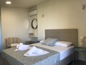 a bedroom with two beds with towels on them at Filippos Resort by the Sea in Vourvourou