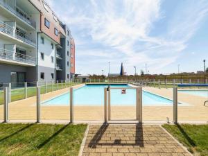 a swimming pool in front of a building at ibis Styles Zeebrugge in Zeebrugge