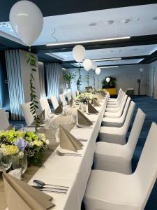 a room with white tables and white chairs and flowers at Arche Hotel Krakowska in Warsaw