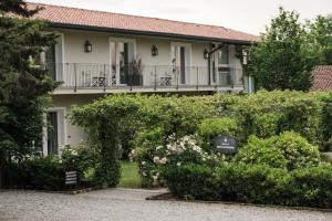 Relais Russiz Superiore في Capriva del Friuli: منزل مع شرفة مع الزهور والشجيرات