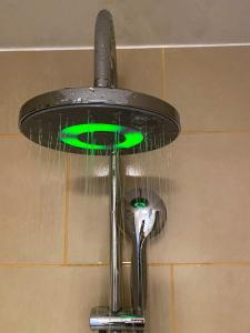 a shower head with a green light in a bathroom at Green Caroline in Berlin