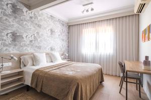 a bedroom with a bed and a table and a desk at Aspasios Rambla Catalunya Suites in Barcelona