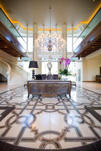 um grande átrio com uma mesa e um lustre em Pivot Hotel Montecasino em Joanesburgo