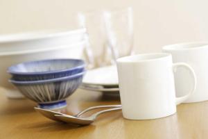 a table with two bowls and a white mug at FLEXSTAY INN Shirogane in Tokyo