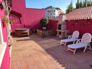 a patio with two chairs and a pink wall at Casa Marina in Ribeira