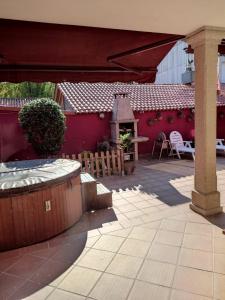 a patio with a red building and a table and chairs at Casa Marina in Ribeira +16 photos