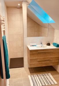 baño con lavabo y luz azul en Les Pieds dans l'Herbe, en Rosporden