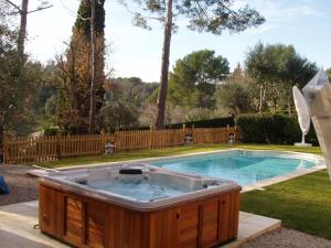 a hot tub in a yard with a fence at Villa Bois Doré in Valbonne