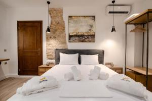 a bedroom with a white bed with two white pillows at Curcumelli Luxury Suites - ΠΟΡΤΟΝΙ 1 in Corfu Town
