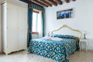 - une chambre avec un lit doté d'un couvre-lit bleu dans l'établissement Al Mascaron Ridente, à Venise