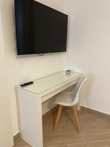 un escritorio blanco con TV en la pared en Casa AnnaBella en Trapani