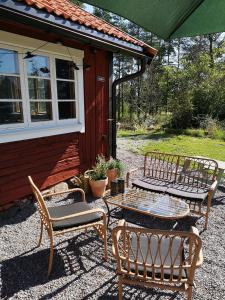 duas cadeiras e uma mesa em frente a uma casa em Smedjan cottage em Enköping