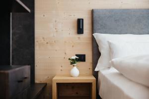 a vase of flowers on a table next to a bed at Chalet Dolecir in La Valle +34 photos