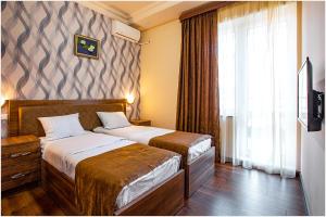 una camera d'albergo con due letti e una finestra di Arma Boutique Hotel a Yerevan