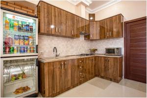 a kitchen with wooden cabinets and a refrigerator at Arma Boutique Hotel in Yerevan