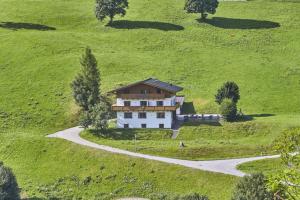 a large house on a green hill with a winding road at Chalet Wallehen in Saalbach Hinterglemm