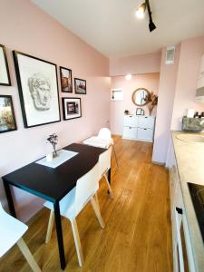 a dining room with a black table and white chairs at SUNSET Apartment Near Sea - family friendly space with bath and good coffee in Ventspils