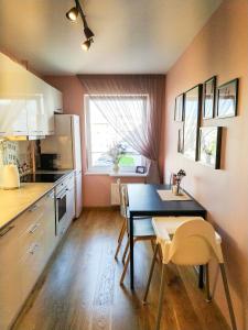 a kitchen with a table and chairs in a room at SUNSET Apartment Near Sea - family friendly space with bath and good coffee in Ventspils