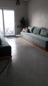 a living room with a couch and a table at Appart. Luxueux avec piscine, cosy, bien situé in Bouznika +20 photos