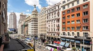 マドリードにあるGran Vía 55 Exclusive Apartmentsの道路上の建物や車が並ぶ賑やかな街道