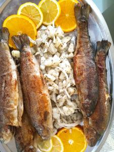 a plate of food with fish and rice and oranges at Guesthouse Eko Piva in Pluzine