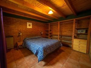 1 dormitorio con cama y pared de ladrillo en Complejo Turistico Bambu en El Bolsón