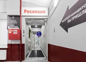 a hallway in a building with a sign on the wall at Nomera na Nevskom 111 in Saint Petersburg