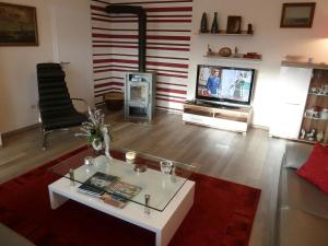 ein Wohnzimmer mit einem Tisch und einem TV in der Unterkunft Das Gabionenhaus in Schmallenberg