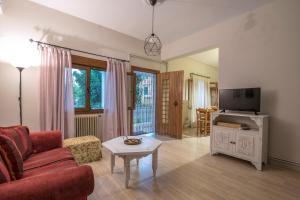 a living room with a red couch and a tv at KERASIA'S COUNTRY HOUSE in Volos