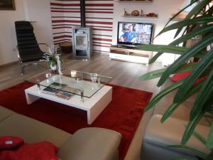 een woonkamer met een salontafel en een televisie bij Das Gabionenhaus in Schmallenberg