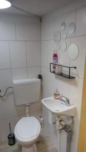 a white bathroom with a toilet and a sink at Bauernhof Oase in Bestensee