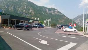 a parking lot with cars parked in front of a mountain at Guesthouse Eko Piva in Pluzine