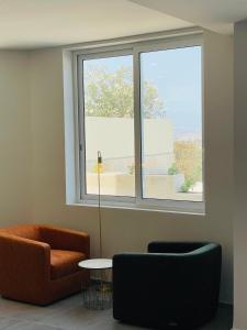 a living room with a couch and a window at Hotel VIU57 in Mellieħa