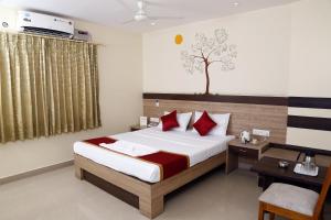 een hotelkamer met een bed en een bureau en een bed sidx sidx sidx sidx bij HOTEL GREEN TREES in Bangalore