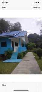 a blue house with a blue roof and a sidewalk at The Mountain View Hat Sai Ri Resort in Chumphon