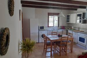 kuchnia ze stołem, krzesłami i zlewem w obiekcie Casa rural Cortijo El Verdial w mieście Torrox