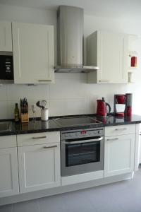 een keuken met witte kasten en een kookplaat oven bij Quartier an der Elbe in Dresden