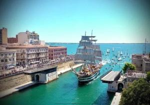 Ein großes Boot liegt in einem Fluss in einer Stadt angedockt in der Unterkunft Taras holiday house in Taranto