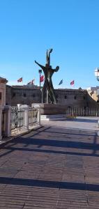 eine Statue in der Mitte eines Gebäudes mit Flaggen in der Unterkunft Taras holiday house in Taranto + 9 Fotos