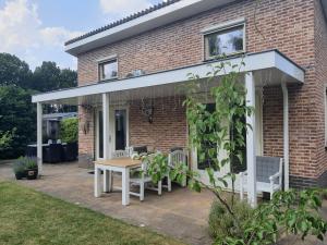 een patio met een houten tafel en stoelen bij Het Groene Hart in Putten