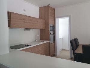a kitchen with wooden cabinets and a counter top at Ivett apartmanház in Balatonlelle