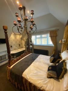 a bedroom with a large bed with a chandelier at Varr House @ Meadow View in Woodmancote