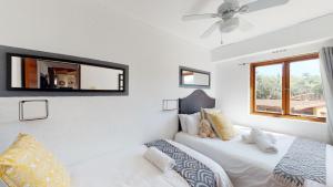 1 Schlafzimmer mit 2 Betten und einem Wandspiegel in der Unterkunft San Lameer Villa 2008 by Top Destinations Rentals in Southbroom