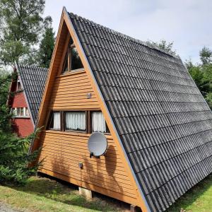 una pequeña casa con techo de gambrel en Ferienhaus Toso, en Freyung
