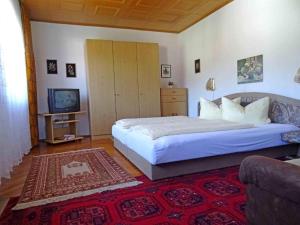 1 dormitorio con 1 cama grande y TV en Ferienwohnungen Reimer, en Kiefersfelden