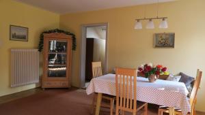 ein Esszimmer mit einem Tisch mit einer Blumenvase darauf in der Unterkunft Ferienwohnung Leitner in Kiefersfelden + 6 Fotos