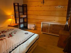 a bedroom with a bed and a wooden wall at Domki w Bieszczadach Cisna in Cisna