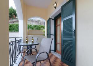 a balcony with a table and chairs and a door at Balis Apartments in Paleokastritsa