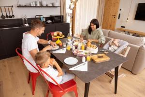 a family sitting at a table eating food at das bleibt Alpine Suites in Schladming +94 photos